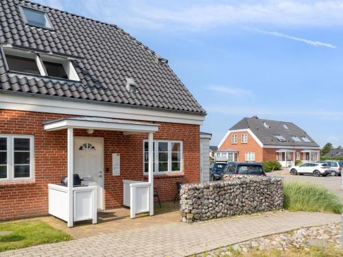 a red brick house with a white door at Holiday Home Langsom - 100m from the sea by Interhome in Havneby