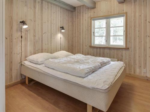 ein Schlafzimmer mit einem Bett in einem Zimmer mit einem Fenster in der Unterkunft Holiday Home Volmar - 3-5km from the sea by Interhome in Kongsmark