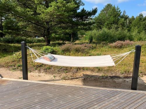 eine Hängematte, die an zwei Stangen auf einem Feld hängt in der Unterkunft Holiday Home Thorulf - 3-5km from the sea by Interhome in Kongsmark
