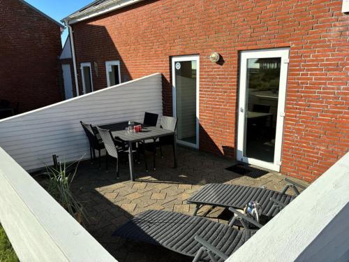 a patio with a table and chairs next to a brick building at Apartment Bosse - 2-3km from the sea by Interhome in Sønderby
