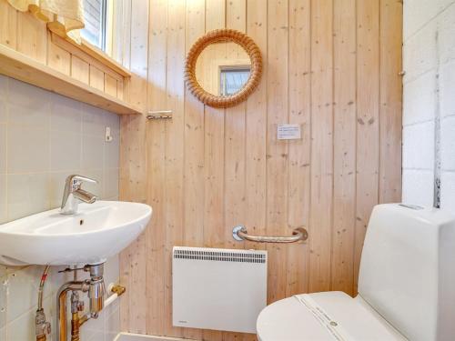 a bathroom with a sink and a toilet and a mirror at Holiday Home Nandolf - 3-5km from the sea by Interhome in Bolilmark