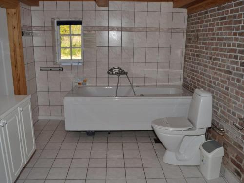 a bathroom with a white tub and a toilet at Holiday Home Botmund - 3-6km from the sea by Interhome in Bolilmark