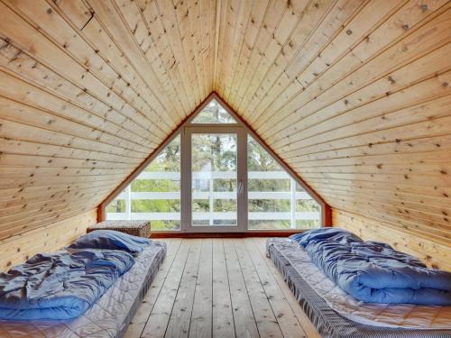 two beds in a wooden room with a large window at Holiday Home Antero - 4km from the sea by Interhome in Toftum