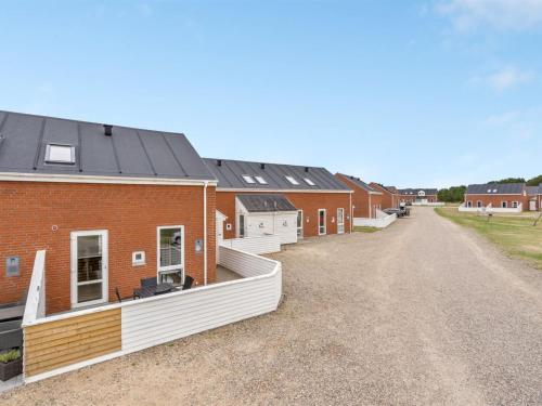 a row of brick houses on a dirt road at Apartment Anke - 500m from the sea by Interhome in Sønderby