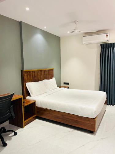 a bedroom with a bed and a desk and a chair at Hotel Skyview Suites & Studios in Hyderabad