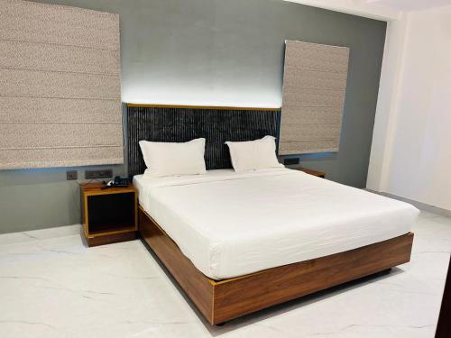 a bedroom with a large bed with white sheets at Hotel Skyview Suites & Studios in Hyderabad