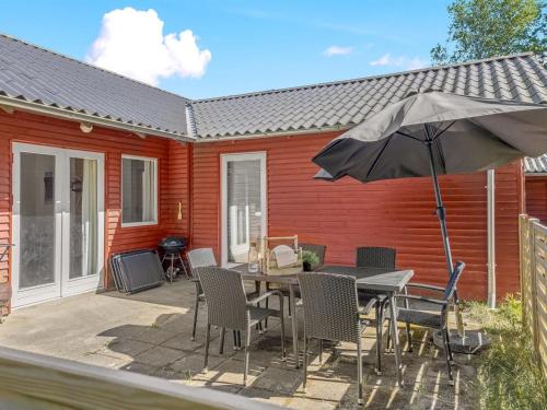un patio avec une table et un parasol dans l'établissement Holiday Home Dorreth - 800m from the sea by Interhome, à Mølby
