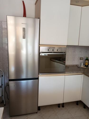 een roestvrijstalen koelkast in een keuken met witte kasten bij Villa Cesarea in Porto Cesareo