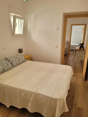 a bedroom with a large white bed in a room at Apartamento con WiFi y aparcamiento privado in Alcalá de Guadaira
