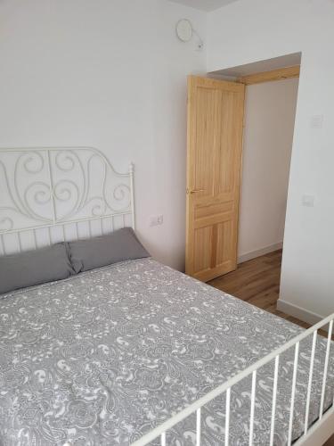 a bedroom with a bed and a wooden door at Apartamento con WiFi y aparcamiento privado in Alcalá de Guadaira