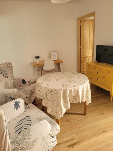 a living room with a table and a tv at Apartamento con WiFi y aparcamiento privado in Alcalá de Guadaira