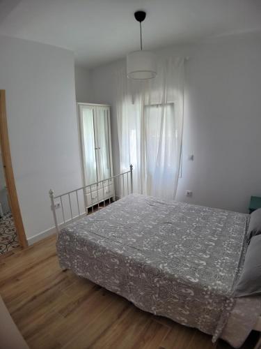 a bedroom with a bed and two windows at Apartamento con WiFi y aparcamiento privado in Alcalá de Guadaira