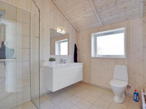 a bathroom with a toilet and a glass shower at Holiday Home Jonna - 700m from the sea by Interhome in Lakolk