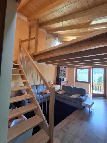 a living room with a staircase and a couch at Chalet Cà Modest in Grosotto