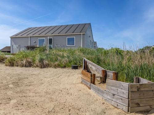 a house on the beach with a wooden fence at Holiday Home Eldora - 1-4km from the sea by Interhome in Lakolk