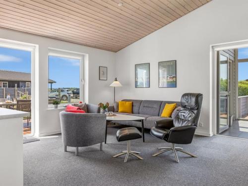 a living room with a couch and chairs and a table at Holiday Home Eldora - 1-4km from the sea by Interhome in Lakolk