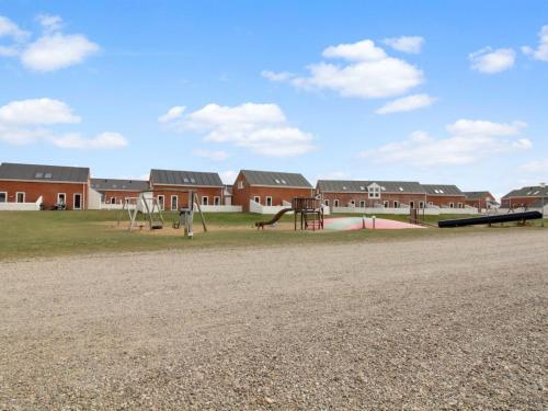 un parque infantil frente a un edificio en Apartment Lotte - 2-3km from the sea by Interhome, en Sønderby