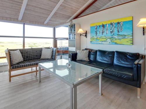 a living room with a couch and a glass table at Holiday Home Alim - 300m from the sea by Interhome in Lakolk