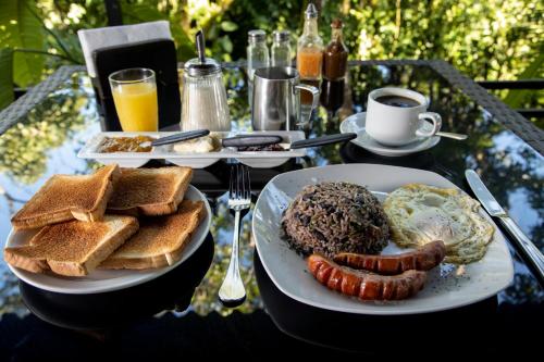 a table topped with plates of breakfast foods and drinks at Tapirus Lodge and Reserve in Carrillo
