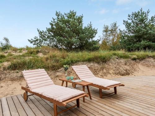 two chairs and a table on a wooden deck at Holiday Home Merta by Interhome in Toftum