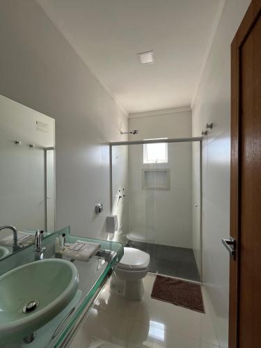 a bathroom with a glass sink and a toilet at Hotel Uipi in Sorriso