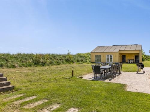 a yellow house with a table and chairs in a field at Holiday Home Narvik - 4-5km from the sea by Interhome in Kongsmark