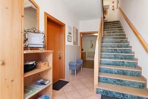 a staircase in a room with a blue chair at Auelehof Laives in Laives