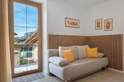 a couch with yellow pillows in a room with a window at Auelehof Laives in Laives
