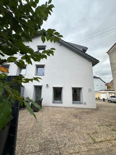 a white house with windows on the side of it at Große 2 Ferienwohnung Gästehaus NEUBAU Merzig 100 m2 in Merzig