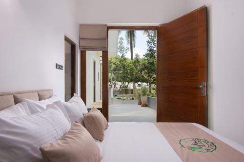 a bedroom with a bed and a wooden door at Mr & Mrs K's Villa- Kandy in Kandy