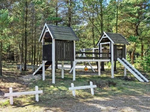 a playground in a park with two play structures at Holiday Home Jensen - 700m to the fjord by Interhome in Oksbøl