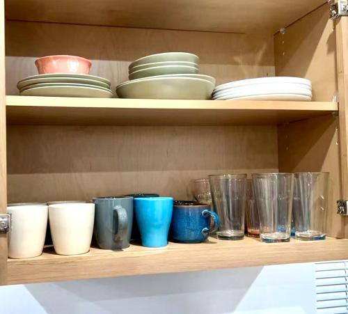 a shelf with bowls and cups and plates on it at Culver Hideaway Private Room with Share Living Space C1 in Los Angeles