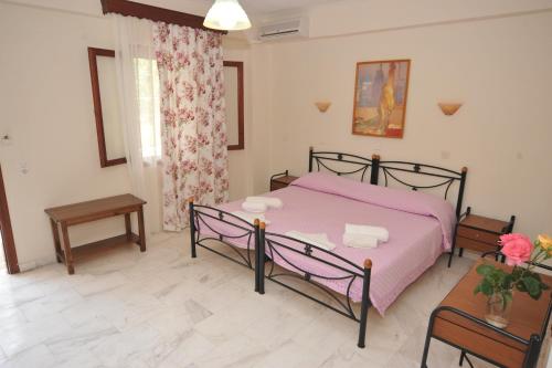 a bedroom with a pink bed and a table at Miramare in Petra