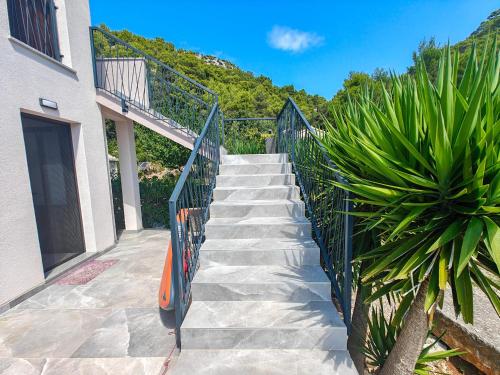 a staircase leading up to a building with a fence at Robinson Edita in Bogomolje