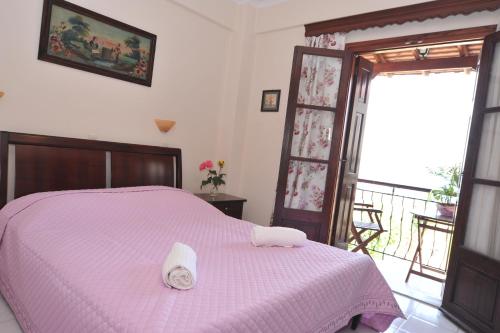 a bedroom with a pink bed and a balcony at Miramare in Petra