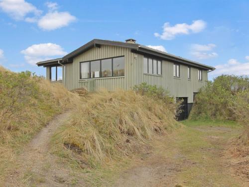 a green house on top of a hill at Holiday Home Lykke - 800m from the sea by Interhome in Vejers Strand