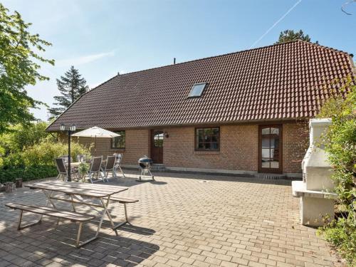 a brick house with a patio with a table and chairs at Holiday Home Iiro - 2-5km from the sea by Interhome in Rømø Kirkeby