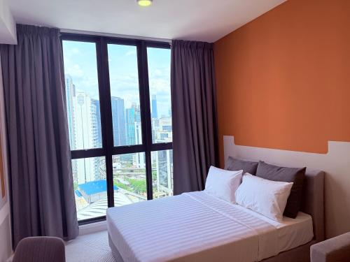 a bedroom with a bed and a large window at Majestic Residence Klcc in Kuala Lumpur