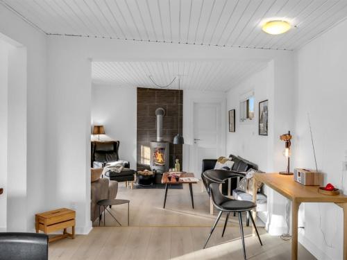 a living room with chairs and a table and a fireplace at Holiday Home Dragan - 350m from the sea by Interhome in Vejers Strand