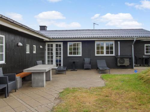 a patio with a table and chairs in front of a house at Holiday Home Dragan - 350m from the sea by Interhome in Vejers Strand