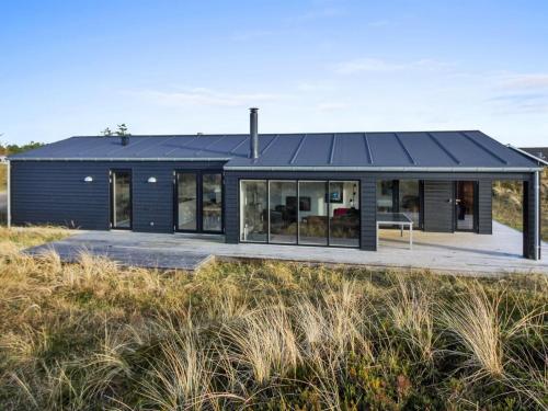 a house with a black roof on the beach at Holiday Home Jirina - 750m from the sea by Interhome in Vejers Strand