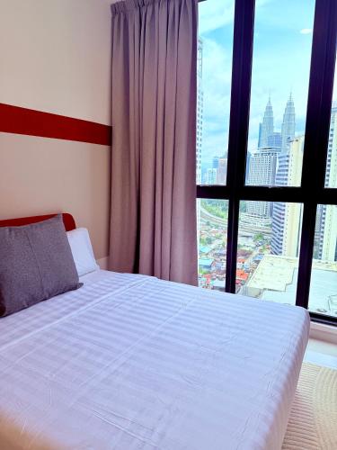 a bedroom with a bed and a large window at Majestic Residence Klcc in Kuala Lumpur