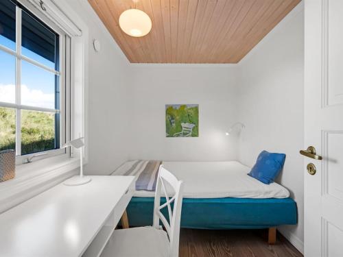 a room with a bed and a desk and a window at Holiday Home Aise - 75m from the sea by Interhome in Vejers Strand