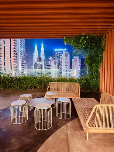 a group of tables and benches in front of a city at Majestic Residence Klcc in Kuala Lumpur