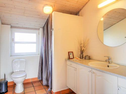 a bathroom with a toilet and a sink and a mirror at Holiday Home Petkana - 700m from the sea by Interhome in Vejers Strand