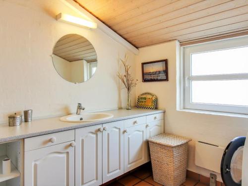 a bathroom with a sink and a mirror at Holiday Home Petkana - 700m from the sea by Interhome in Vejers Strand