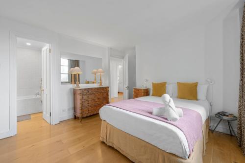 a bedroom with a large bed with a white towel on it at Luxury Spacious 3 Bedroom, 3 Bathroom Apartment, Walk to Soho, West End, Covent Garden, China Town, Piccadilly in Minutes, Complimentary Fast WiFi, Tea & Coffee in London