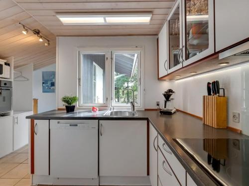 a kitchen with white cabinets and a sink at Holiday Home Andresine - 900m from the sea by Interhome in Vejers Strand