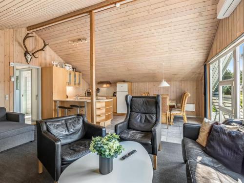 ein Wohnzimmer mit Ledersesseln und einem Tisch in der Unterkunft Holiday Home Sanelma - 900m from the sea by Interhome in Vejers Strand