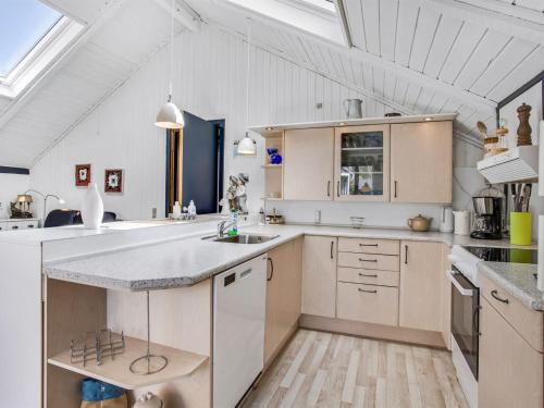 a large kitchen with white cabinets and a sink at Holiday Home Solvejk - 800m from the sea by Interhome in Vejers Strand